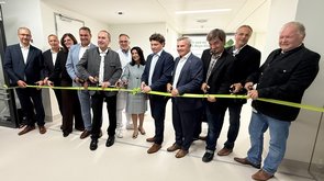 Mehrere Personen durchschneiden ein Band. 